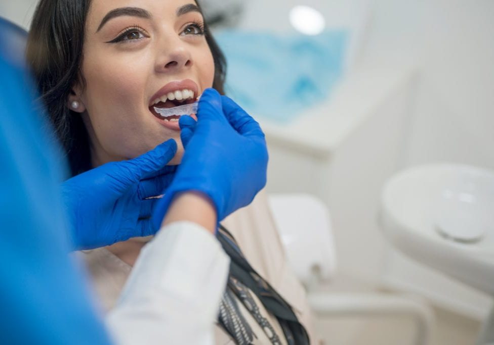 Dentist inserting orthodontic retainers,